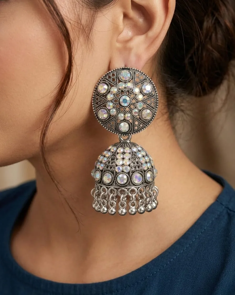Vardaan Crystalx women's earing are stunning oxidized silver jhumkas feature intricate filigree tops sparkling with iridescent multicolored crystals, leading to classic dome bells adorned with shimmering stones and dangling chain tassels with tiny bells. view 2