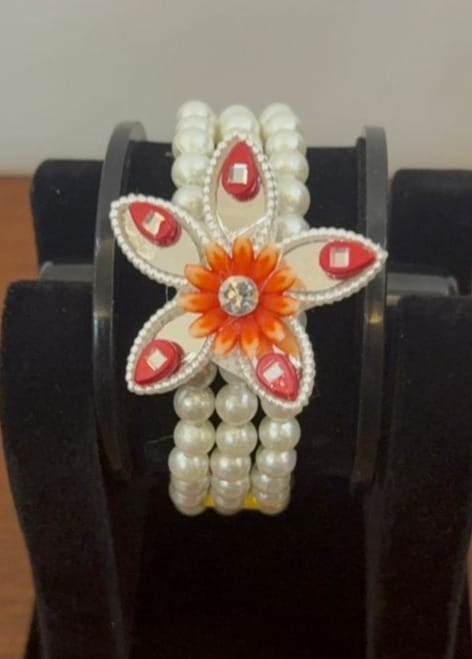 three-layer white moti bracelet featuring an orange floral
