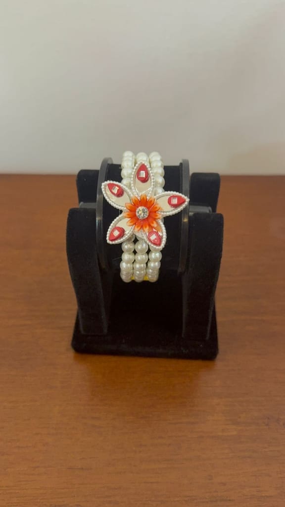 three-layer white moti bracelet featuring an orange floral view 2