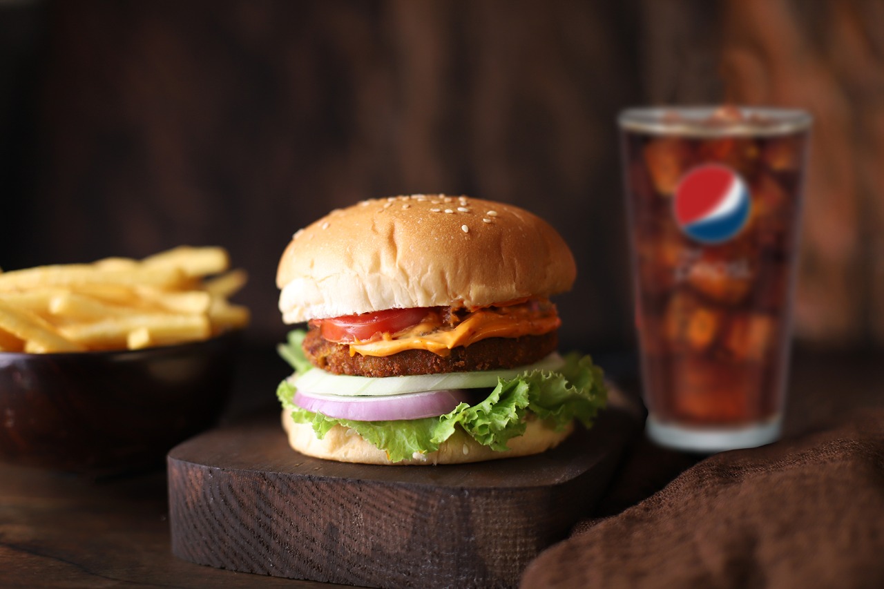 Crumbed mutton burger with fries and pepsi